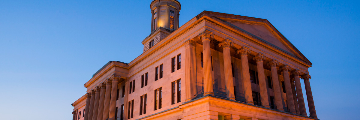 The Tennessee state capital building lit orange at twilight